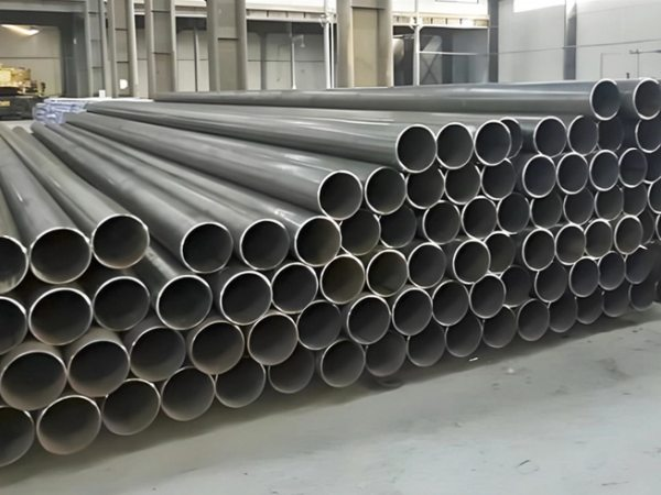 Pila de tubos de acero al carbono de gran diámetro en un almacén industrial, suministrados por DG Importaciones para proyectos de minería y petróleo en Colombia.